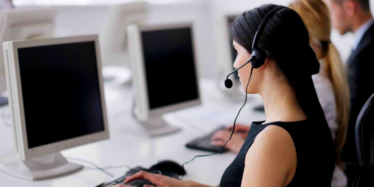 Mulher conversando com headset enquanto digita no computador