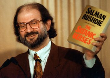 Salman Rushdie com seu livro 'Os Versos Satânicos'