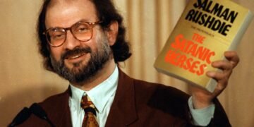 Salman Rushdie com seu livro 'Os Versos Satânicos'