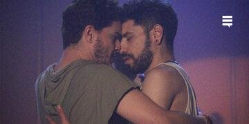 Os atores Igor Kierke e Paulo Soares, juntos, com o rosto colado, dançando