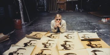 Imagem de Andy Warhol diante de suas serigrafias. Imagem: Autoral Filmes / Divulgação.